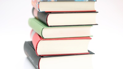 Några ganska tjocka böcker ligger i en hög.