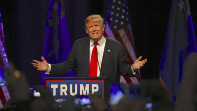 Trump står i en talarstol och gestikulerar.