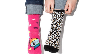 Bild på en persons strumpor som har olika färger och mönster.