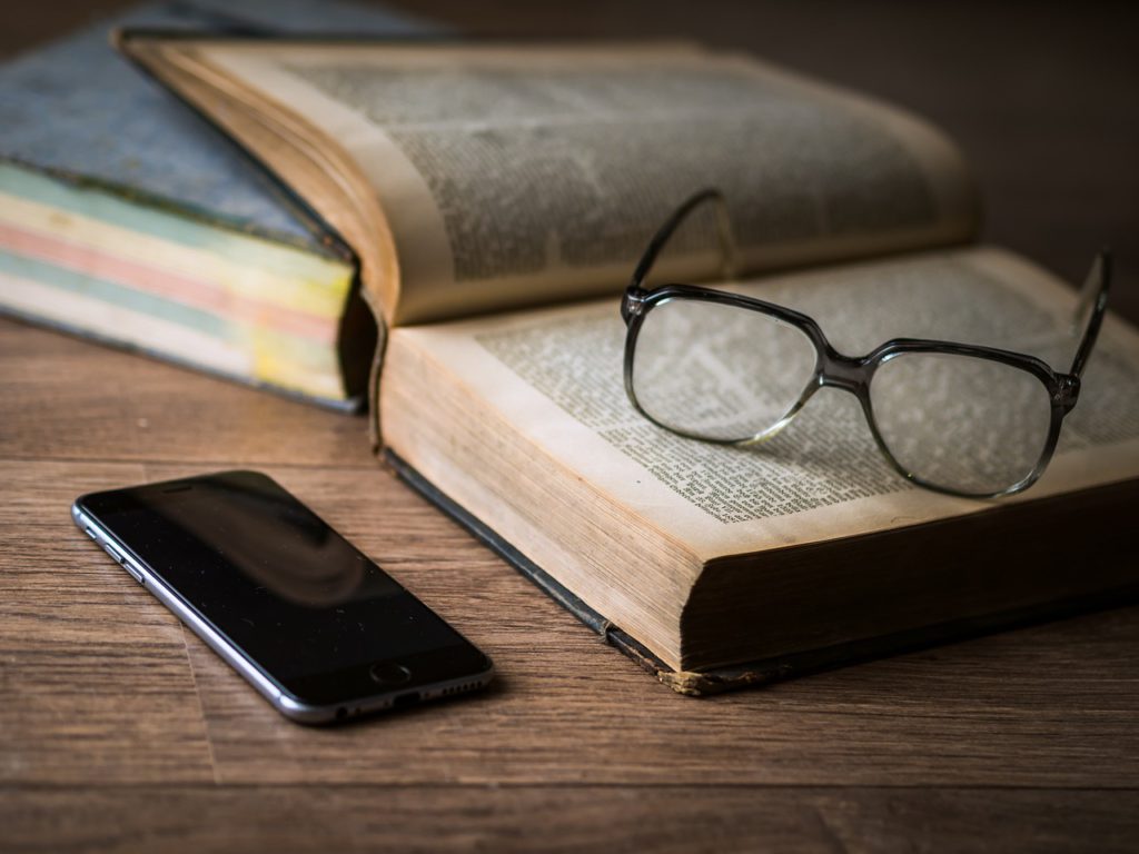 En telefon har lämnats kvar bredvid en uppslagen bok